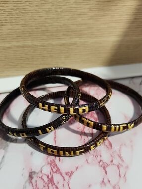Stack of Dark Brown Woven Hoop Bracelets with Yellow Accent